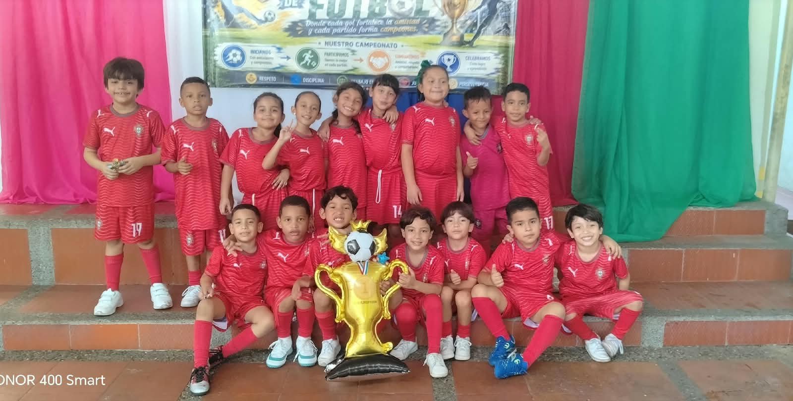 Equipo de fútbol de Personitas celebrando un campeonato